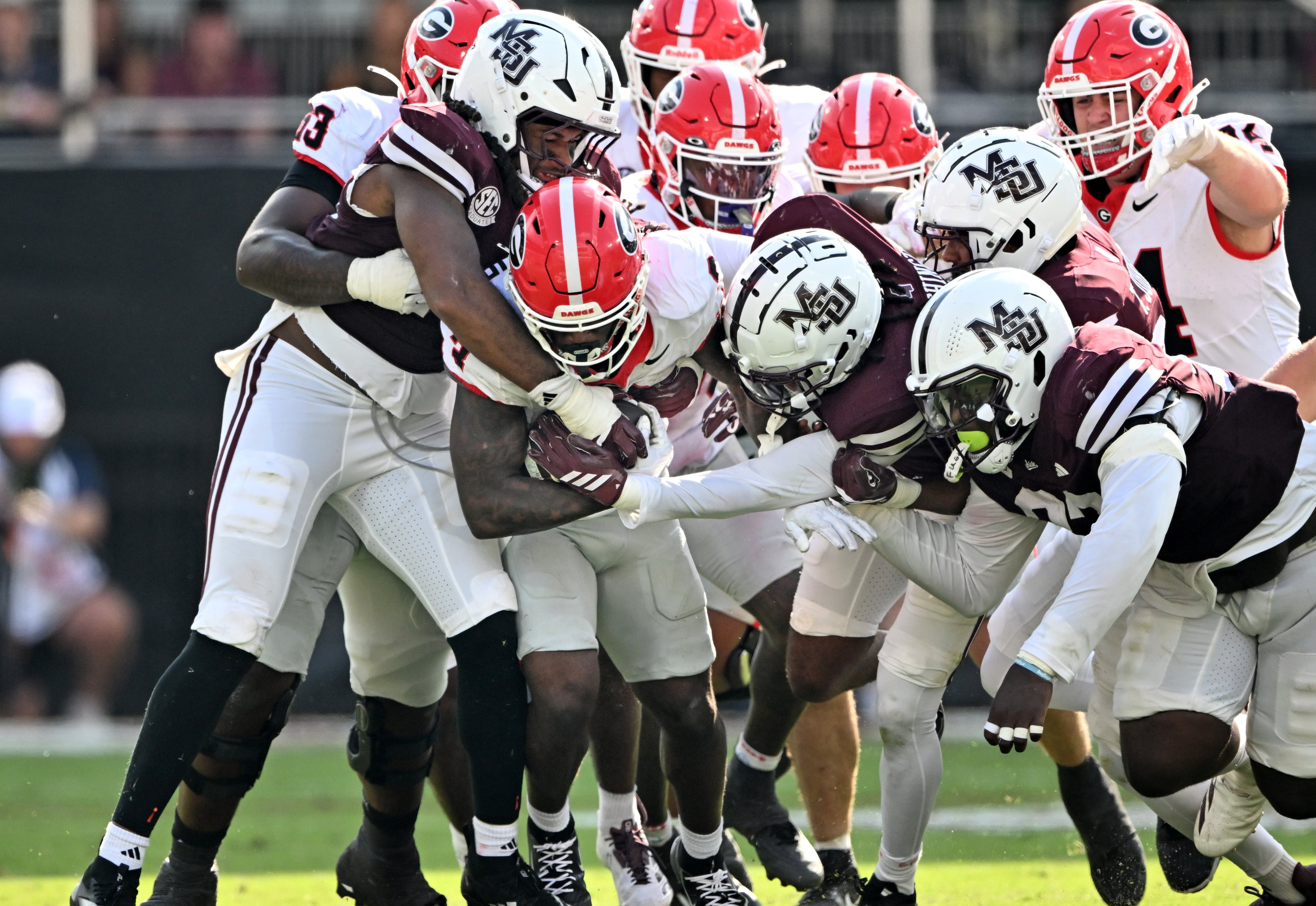 Georgia running back Nate Frazier (3) is brought down by Mississippi State defense players during the second half in an NCAA football game at Davis Wade Stadium, Saturday, November 8, 2025, in Starkville, Mississippi. Georgia won 41-21 over Mississippi State. (Hyosub Shin / AJC)