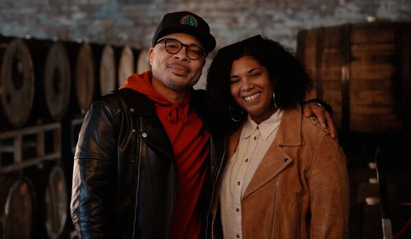 Dennis "Ale Sharpton" Byron and his wife, Andrea Janise, stand in front of barrels filled with beer at Creature Comforts Beer.