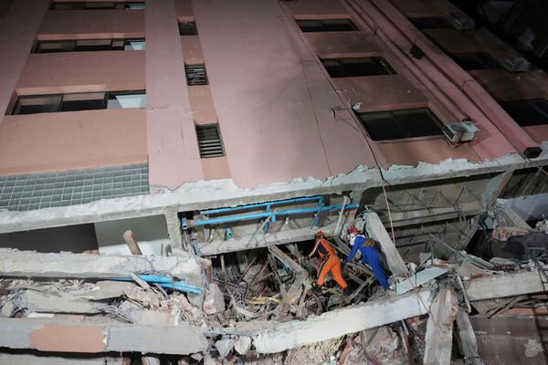 In this photo released by Xinhua News Agency, rescuers search for survivors at a collapsed building in the aftermath of an earthquake in Mandalay, Myanmar on Sunday, March 30, 2025. (Cai Yang/Xinhua via AP)