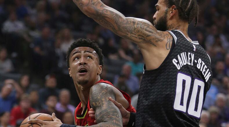The Hawks' John Collins (left) tries to find a path against Kings center Willie Cauley-Stein. (AP Photo/Rich Pedroncelli)