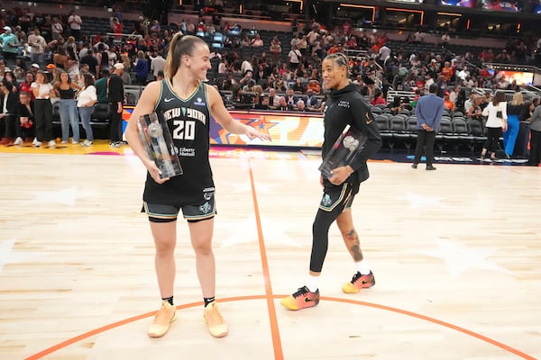New York Liberty's Sabrina Ionescu, left, holds the 3-point contest trophy while New York Liberty's Natasha Cloud holds the skills challenge trophy during the WNBA All-Star basketball weekend, Friday, July 18, 2025, in Indianapolis. (AP Photo/Michael Conroy)