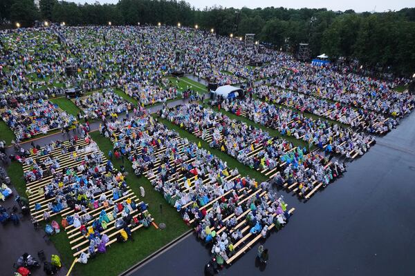 People enjoy the Estonian Song Festival, part of the "Iseoma" Song and Dance Celebration, at the Song Festival Grounds in Tallinn, Estonia, Saturday, July 5, 2025. (AP Photo/Sergei Grits)