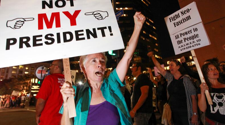 Faith Attaguile, from Encinitas, yells chants with others on the corner of Broadway and Front Street , Wednesday, Nov. 9, 2016, in downtown San Diego, during a protest in opposition of Donald Trump's presidential election victory. (Hayne Palmour IV/The San Diego Union-Tribune via AP)