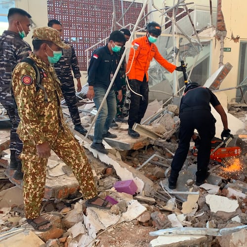In this photo released by the Indonesian National Search and Rescue Agency (BASARNAS), rescuers attempt to clear debris at building damaged by an earthquake in Maumere, East Nusa Tenggara Province, Indonesia, Saturday, Aug. 15, 2026. (BASARNAS via AP)