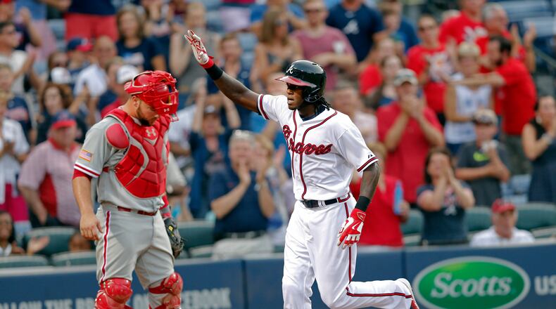 Atlanta Braves’ Cameron Maybin, right, scores after hitting a solo home run in the second inning of a baseball game Saturday, July 4, 2015, in Atlanta. (AP Photo/John Bazemore)