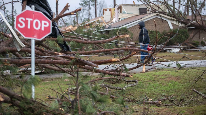A man walks through debris in a neighborhood that was damaged by a Tornado, Monday, Jan. 23, 2017, in Albany, Ga.