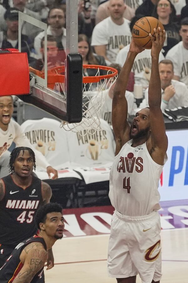Cleveland Cavaliers forward Evan Mobley (4) goes up for a dual in front of Miami Heat guard Davion Mitchell (45) and center Kel'el Ware, center, in the first half in Game 2 of an NBA first-round playoff series, Wednesday, April 23, 2025, in Cleveland. (AP Photo/Sue Ogrocki)