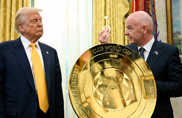 FIFA President Gianni Infantino, right, presents President Donald Trump with a key to unlock the new FIFA Club World Cup trophy in the Oval Office of the White House in Washington, Friday, March 7, 2025. (Pool via AP)
