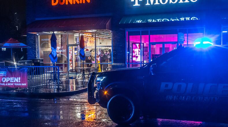 Police converged on Dunkin' at 3068 Panola Road in Lithonia in December 2024. DeKalb County’s chief executive is looking to bolster pay and benefits for police officers. (AJC 2024)