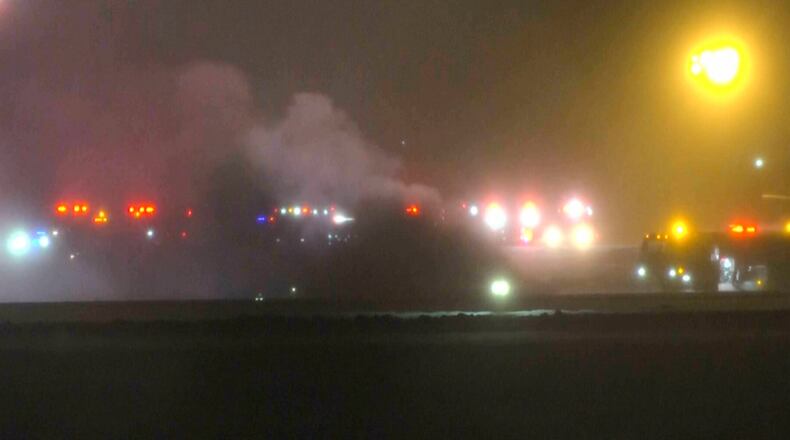 This image taken from video provided by WABI television, emergency services work on a scene of the Bombardier Challenger 600 crash at the Bangor Airport in Maine, late Sunday, Jan. 25, 2026. (WABI via AP)