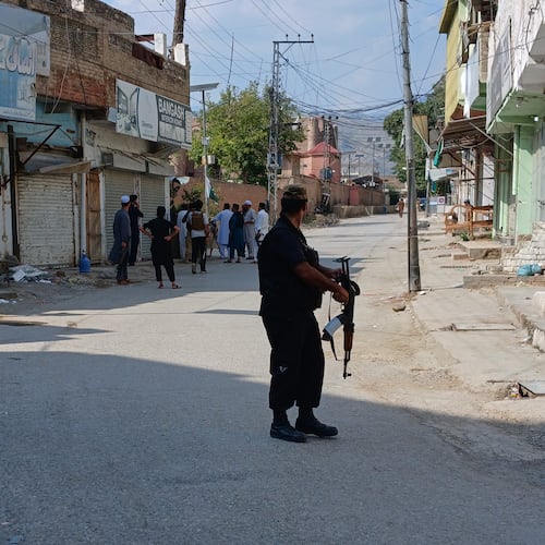In this photo taken with a smartphone, police officers secure a road leading to the site of a powerful bomb at a mosque in Kohat, Pakistan, Friday, Sept. 18, 2026. (AP Photo/B.S. Gillani)
