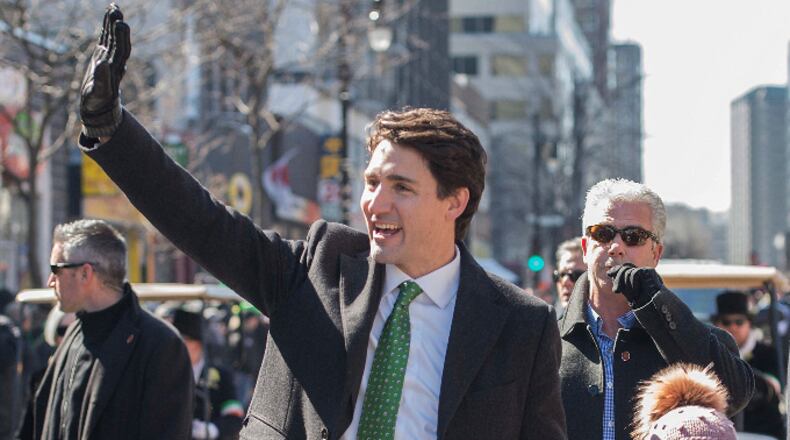 Canada's Prime Minister Justin Trudeau waves to the crowd as he walks with his daughter Ella-Grace during the annual St. Patrick's Day parade in Montreal, Sunday, March 19, 2017. (Graham Hughes/The Canadian Press via AP)