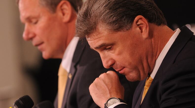 Then-athletic director Dan Radakovich lowers his head as Georgia Tech president G.P. “Bud” Peterson speaks at a news conference July 14, 2011 in response to the school being placed on probation, fined $100,000 and stripped of its 2009 ACC football championship. AJC file photo by Johnny Crawford