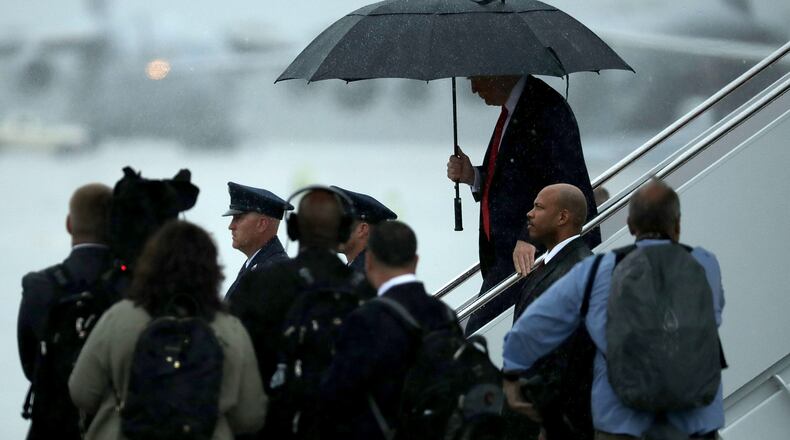 President Donald Trump uses an umbrella after stepping out of Air Force One on Friday. Trump had already announced via Twitter that he had fired chief of staff Reince Priebus and was replacing him with Homeland Security Secretary John Kelly. Chip Somodevilla/Getty Images
