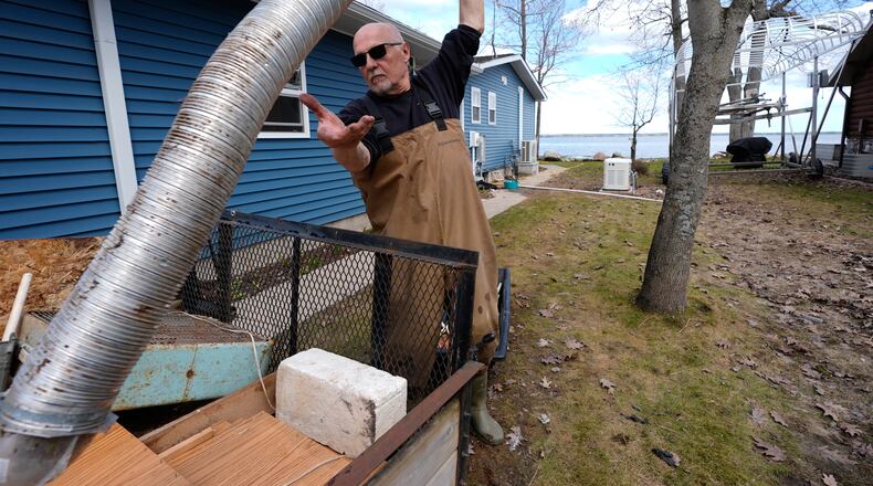 Tom Peterman cleans up outside his home from recent floods at Black Lake on Wednesday, April 29, 2026, in Grant Township, Mich. (AP Photo/Paul Sancya)