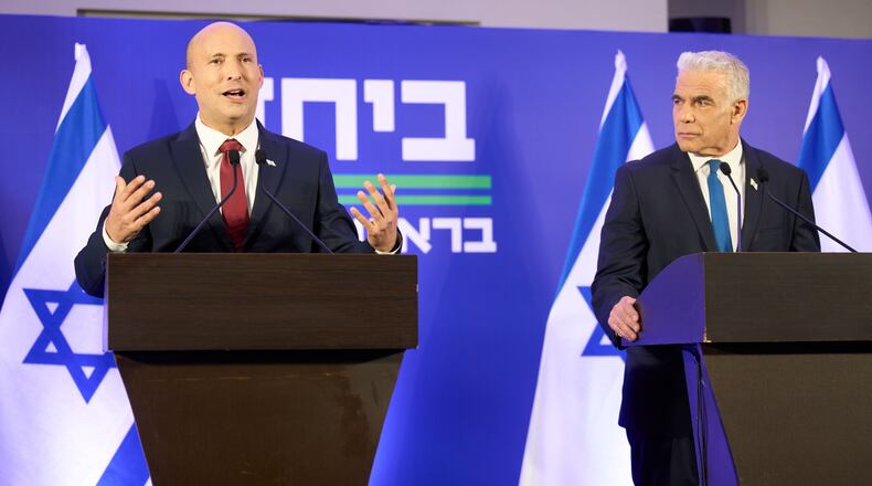 Former Israeli prime ministers Naftali Bennett, left, and Yair Lapid hold a joint press conference announcing that their parties will run together in the upcoming elections, in Herzliya, Israel, Sunday, April 26, 2026. (AP Photo/Ariel Schalit)