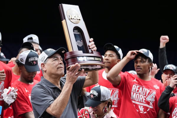 Houston head coach Kelvin Sampson holds the Midwest Region championship trophy after defeating Tennessee in the Elite Eight round of the NCAA college basketball tournament Sunday, March 30, 2025, in Indianapolis. (AP Photo/AJ Mast)