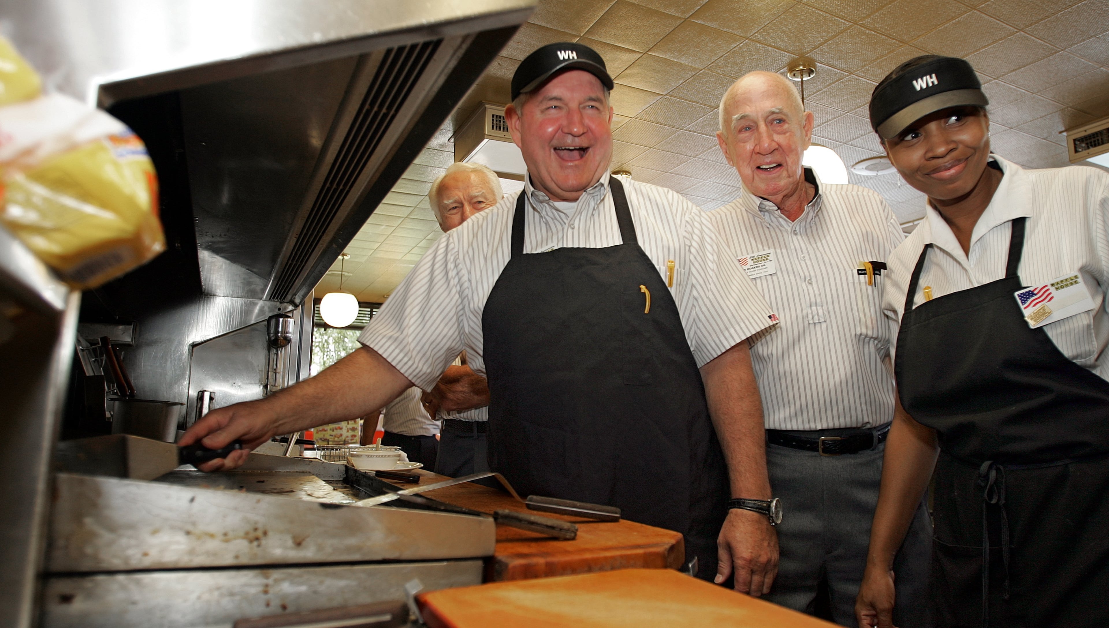 2005: Waffle House founder Tom Forkner. then-Governor Sonny Perdue, Waffle House founder Joe Rogers Sr. and cook Rhonda Anderson gather at Waffle House to celebrate the chain's 50th anniversary.