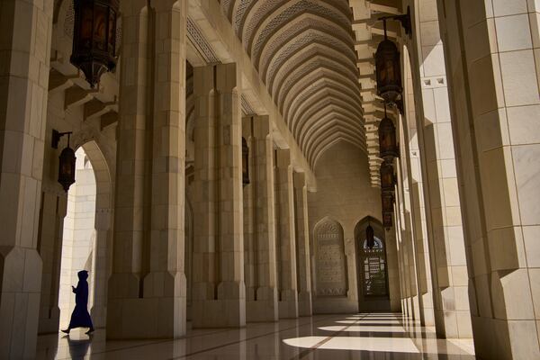A tourist walks through the courtyard of the Sultan Qaboos Grand Mosque in Muscat, Oman, Saturday, April 12, 2025. (AP Photo/ Fatima Shbair)