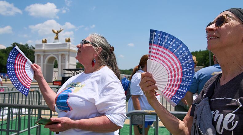 FILE - Mickelina Papotto, of Salem, Ore., left, and Lorie Odegaard, of Gaithersburg, Md., fan themselves while waiting in line for the ferris wheel at the Great American State Fair on the National Mall, July 1, 2026, in Washington. (AP Photo/Jacquelyn Martin, File)