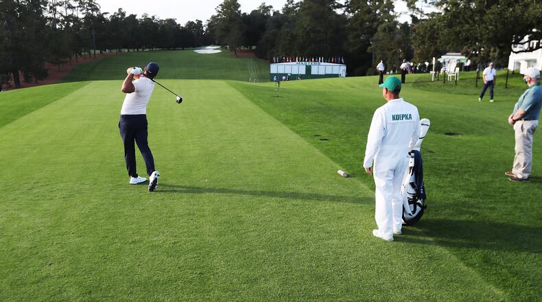 110920 Augusta: The only spectators are his caddy and a gallery guard as Brooks Koepka tees off on the first hole devoid of patrons during the practice round for the Masters Monday, Nov. 9, 2020, at Augusta National Golf Club in Augusta, Ga. The tournament is being held without fans. (Curtis Compton / Curtis.Compton@ajc.com)