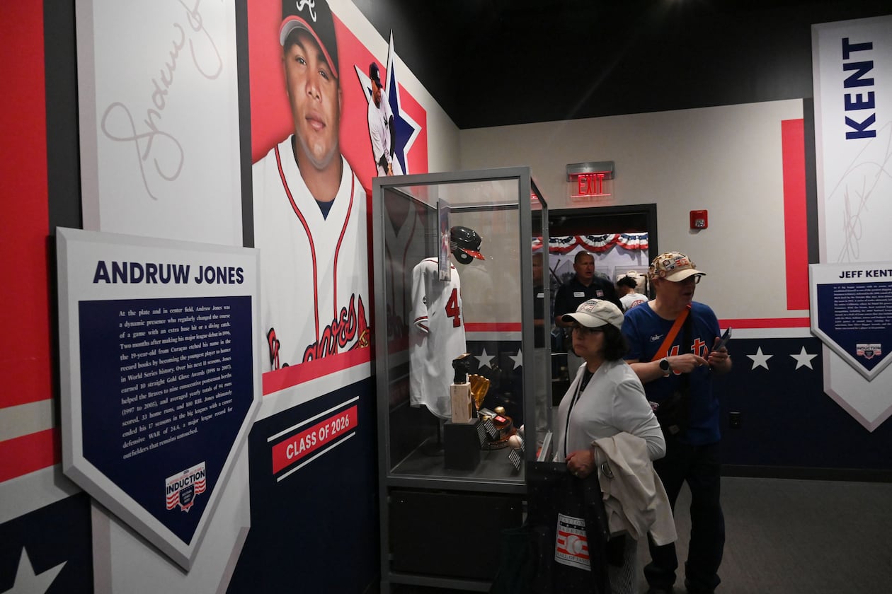 Baseball fans check out displays featuring former Atlanta Braves center fielder Andruw Jones at the National Baseball Hall of Fame and Museum on Friday, July 24, 2026, in Cooperstown, N.Y. Andruw Jones will be inducted into the National Baseball Hall of Fame on Sunday as part of the Class of 2026, alongside Carlos Beltrán and Jeff Kent. He is recognized as one of the greatest center fielders in baseball history. Jones will become the 12th player with ties to the Atlanta Braves to be inducted into the Hall of Fame. (Hyosub Shin/AJC)