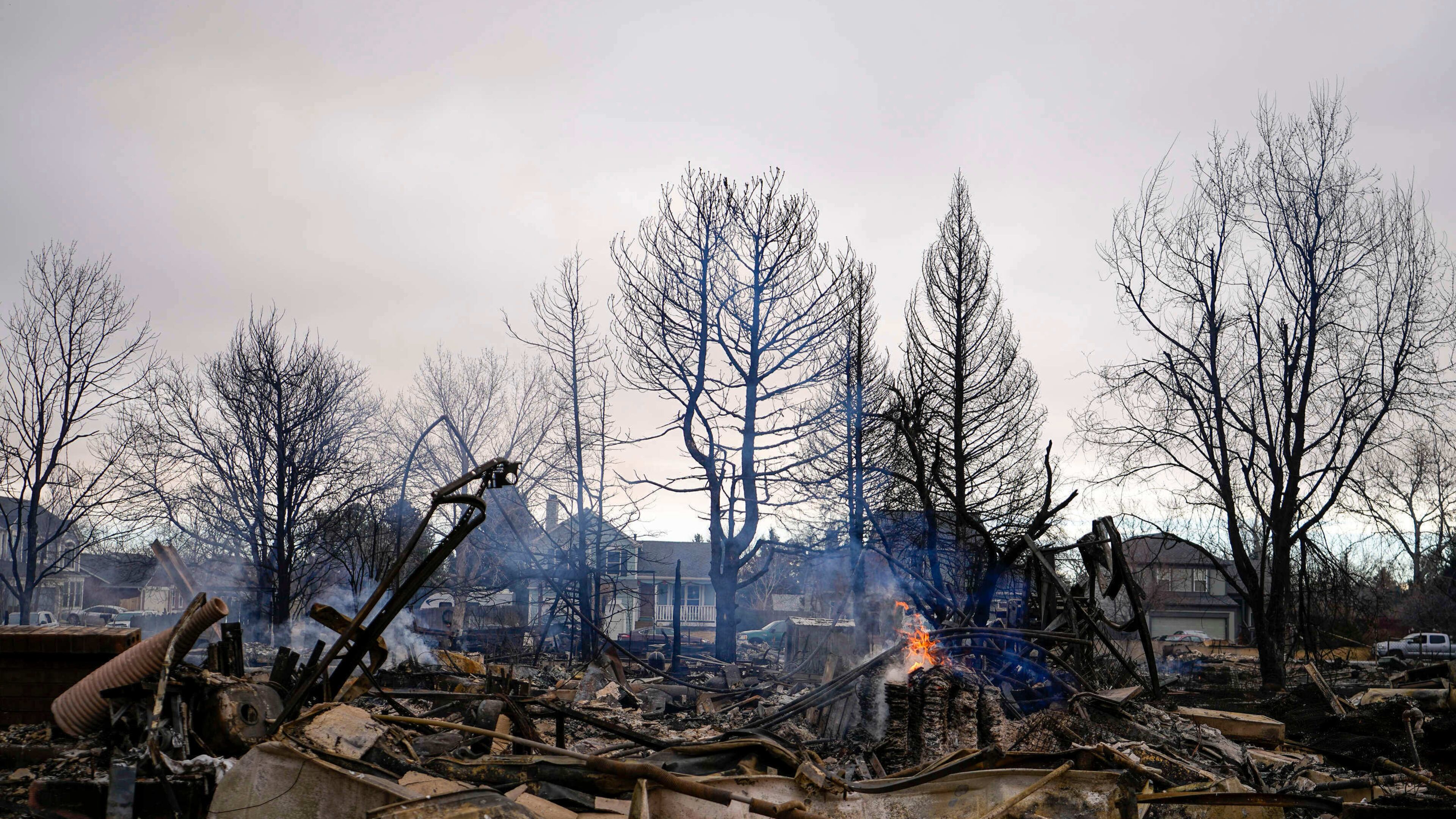 FILE - A fire burns in a home destroyed by the Marshall Wildfire in Louisville, Colo., Dec. 31, 2021. (AP Photo/Jack Dempsey, File)