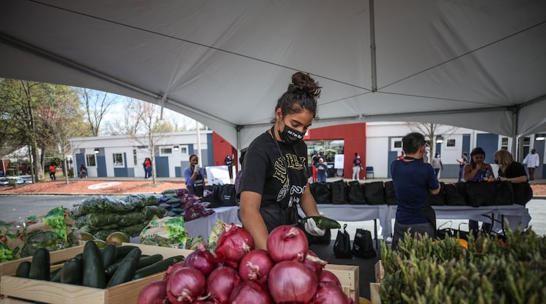 A woman grabs fresh produce at the first of five pop-up grocery store locations. BRANDEN CAMP/SPECIAL