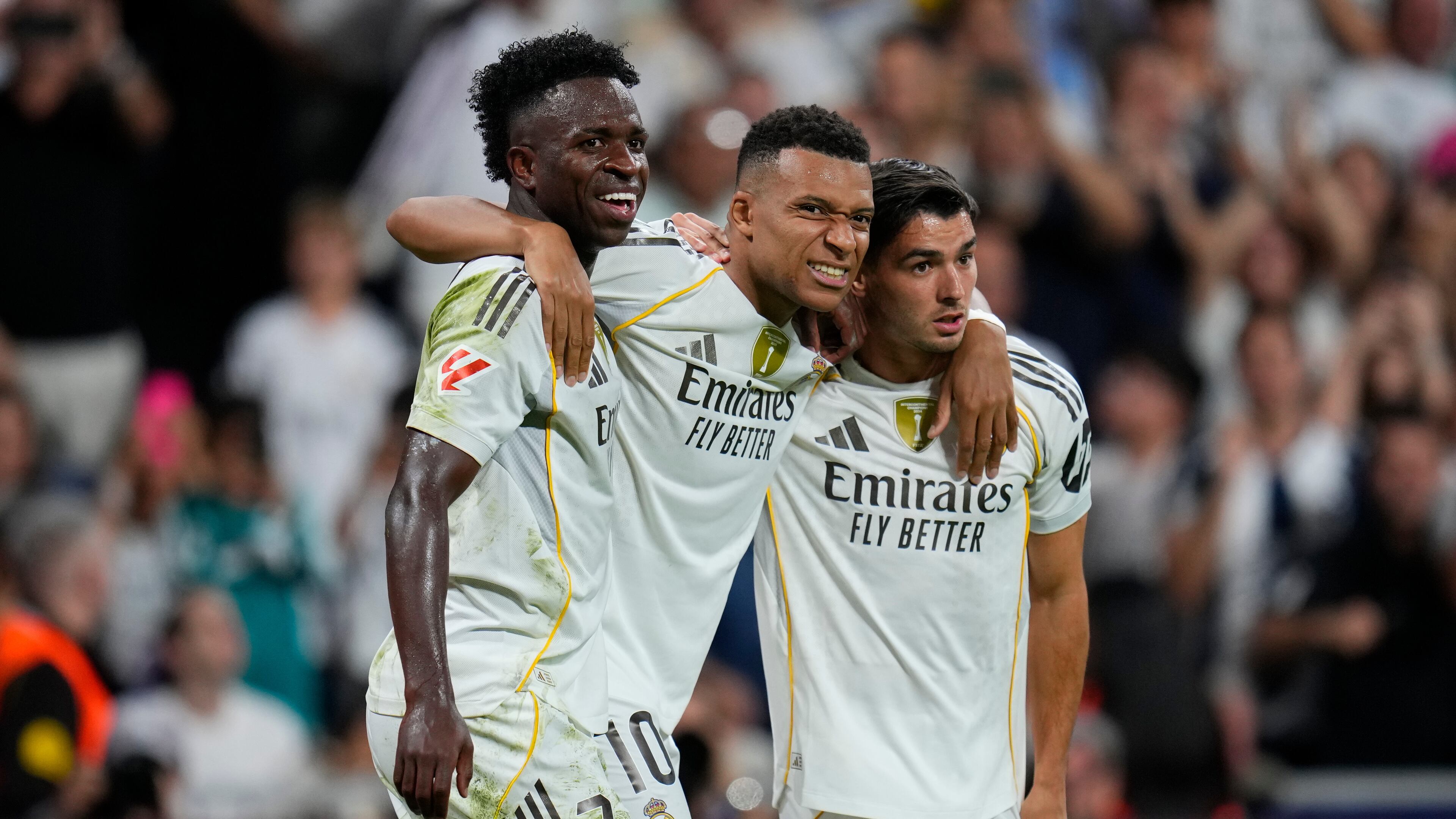 Real Madrid's Kylian Mbappe, centre, celebrates with Vinicius Junior, left, and Brahim Diaz after scoring his side's third goal during the Spanish La Liga soccer match between Real Madrid and Villarreal at the Santiago Bernabeu stadium in Madrid, Spain, Saturday, Oct. 4, 2025. (AP Photo/Manu Fernandez)