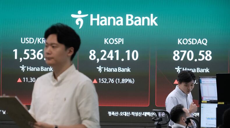 Currency traders work near a screen showing the Korea Composite Stock Price Index (KOSPI) and the foreign exchange rate between U.S. dollar and South Korean won at the foreign exchange dealing room of the Hana Bank headquarters in Seoul, South Korea, Monday, July 6, 2026. (AP Photo/Ahn Young-joon)