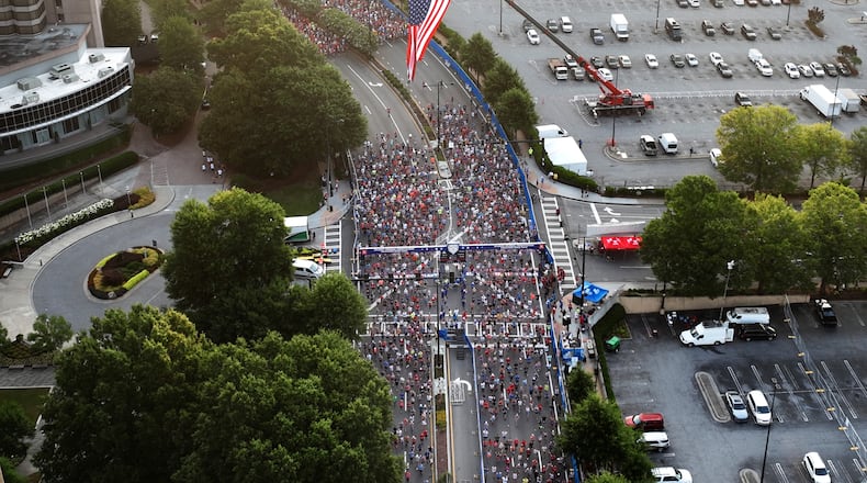 July 4, 2022 Atlanta - Aerial view shows runners cross the starting line of the 53rd Atlanta Journal Constitution Peachtree Road Race near Lenox Square Mall in Atlanta on Monday, July 4, 2022. (Hyosub Shin / Hyosub.Shin@ajc.com)