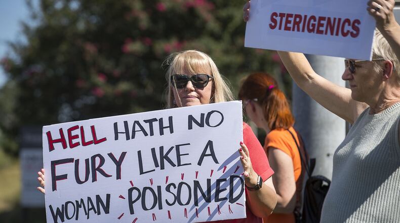 Jenni Shover of Smyrna (center) holds a sign during a protest against a Cobb County Sterigenics plant at the intersection of Atlanta Road and Plant Atkinson Road, Thursday, August 29, 2019. (Alyssa Pointer/alyssa.pointer@ajc.com)