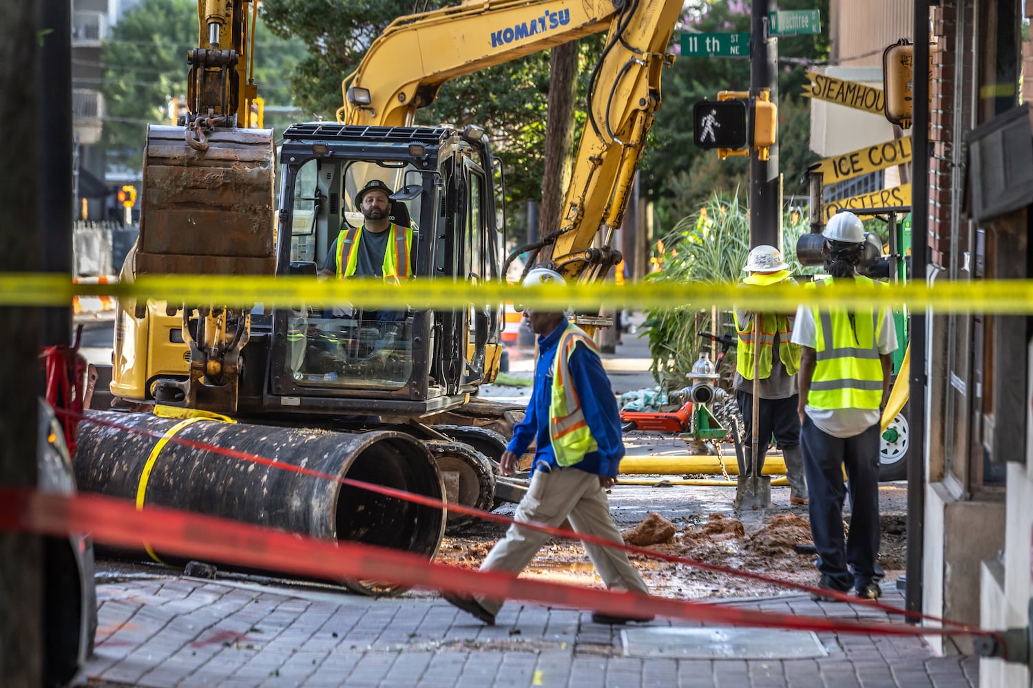 Crews are continuing to work on a broken main on West Peachtree Street in Midtown, with nearby residents warned of impacts to their water service as the crisis reached its fourth day Monday, June 3, 2024. Water had been gushing out of the broken main until Monday morning, when workers were seen pumping out water. (John Spink/AJC)