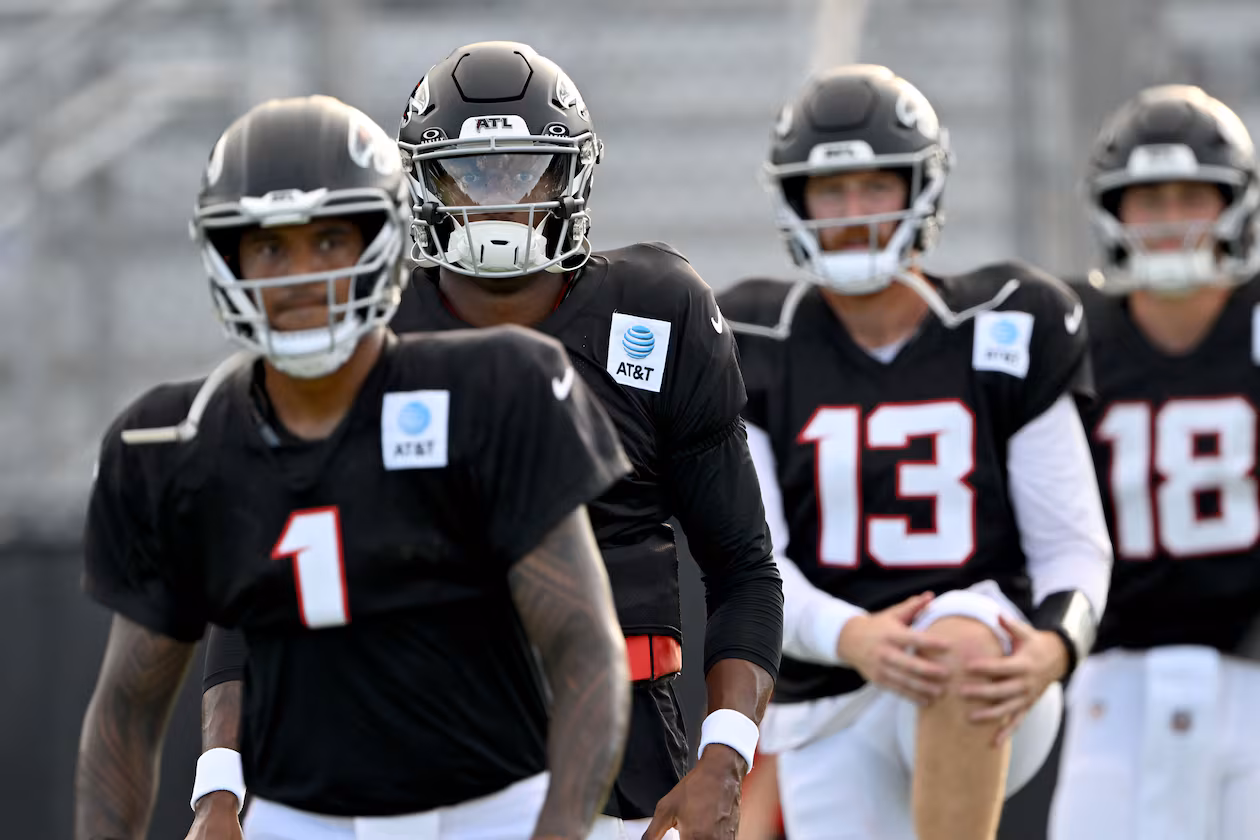 Atlanta Falcons quarterbacks, from left, Tua Tagovailoa (left), Michael Penix Jr. (second from left), Cooper Rush (second from right) and Jack Strand (right) warm up during the Atlanta Falcons' Saturday Night Lights practice at Lanier High School on Saturday, Aug. 8, 2026, in Sugar Hill. (Hyosub Shin/AJC)