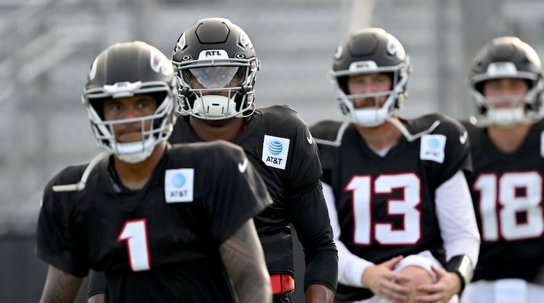 Atlanta Falcons quarterbacks, from left, Tua Tagovailoa (left), Michael Penix Jr. (second from left), Cooper Rush (second from right) and Jack Strand (right) warm up during the Atlanta Falcons' Saturday Night Lights practice at Lanier High School on Saturday, Aug. 8, 2026, in Sugar Hill. (Hyosub Shin/AJC)