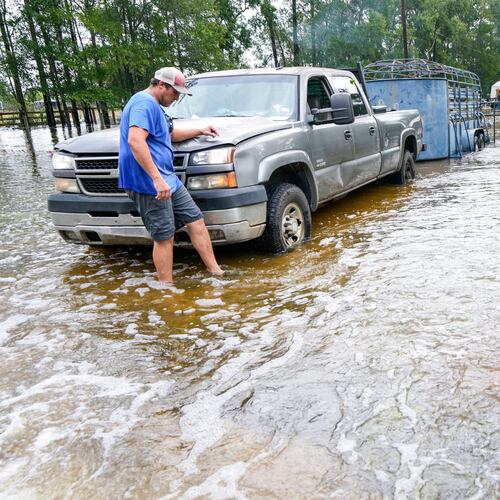 Chase Barfield walks to his truck as he takes belongings and his dogs away from floodwaters around his house in the aftermath of Tropical Storm Edouard near Honey Island, Texas, Wednesday, Sept. 2, 2026. (Brett Coomer/Houston Chronicle via AP)