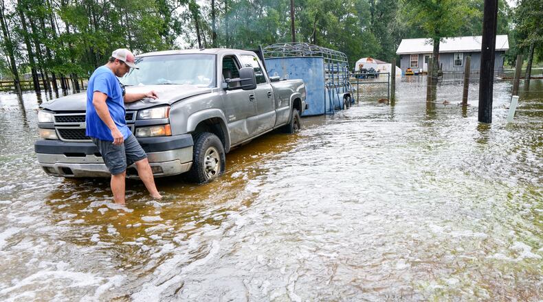 Chase Barfield walks to his truck as he takes belongings and his dogs away from floodwaters around his house in the aftermath of Tropical Storm Edouard near Honey Island, Texas, Wednesday, Sept. 2, 2026. (Brett Coomer/Houston Chronicle via AP)