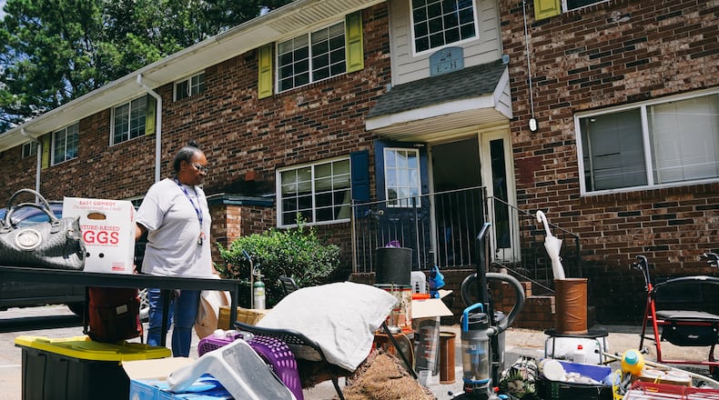 Constance Alford looks over her belongings strewn in the parking lot of her apartment building after her eviction due to alleged unpaid rent in southwest Atlanta, Georgia on Monday, July 24, 2023. (Olivia Bowdoin for the Atlanta Journal-Constitution)