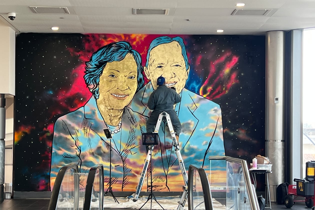 Artist Fabian Williams completes a mural of Jimmy and Rosalynn Carter at Hartsfield-Jackson Atlanta International Airport. (Kelly Yamanouchi/AJC)