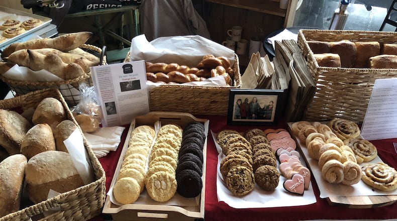 Just Bakery makes more than just bread. This table ready for display at a local farmers market includes epis, challah, cheese and herb bread; six kinds of cookies, including jeera, a Nepalese cumin shortbread; and orange currant and cinnamon rolls. CONTRIBUTED BY JUST BAKERY OF ATLANTA