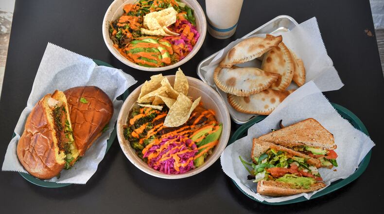 211026 Tucker, Ga: Top row from left: Lime to Me, Ginger Mango Pineapple (20 oz juice), Corn and Potato Empanada. From bottom row left: Chorizo Torta sandwich, Papi's Bowl, MBLTA sandwich.  First Look at Papi Ali's, 2323 Main Street, Suite A1, Tucker, Ga. For 110221firstlook. (Chris Hunt for The Atlanta Journal-Constitution)