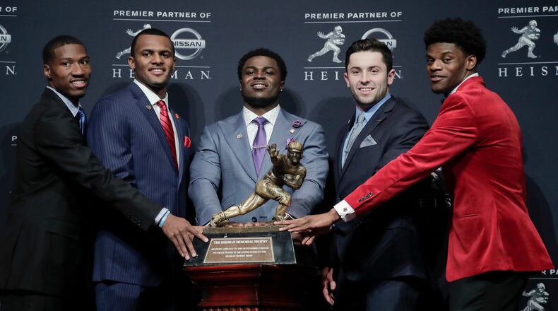 Heisman Trophy finalists, from left, Oklahoma's Dede Westbrook, Clemson's Deshaun Watson, Michigan's Jabrill Peppers, Oklahoma's Baker Mayfield and Louisville's Lamar Jackson stand for a photo with the Heisman Trophy before attending the Heisman Trophy award ceremony, Saturday, Dec. 10, 2016, in New York. (AP Photo/Julie Jacobson)