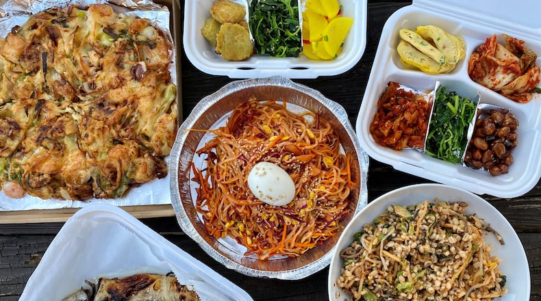 A takeout feast from Yet Tuh includes (clockwise from top left): scallion and seafood pancake, two containers of banchan, boribap, grilled mackerel and spicy cold noodles.
Wendell Brock for The AJC