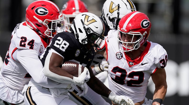 Georgia defensive back Malaki Starks (24) and linebacker Chaz Chambliss, right, tackle Vanderbilt running back Sedrick Alexander (28) in the second half of an NCAA college football game Saturday, Oct. 14, 2023, in Nashville, Tenn. (AP Photo/George Walker IV)