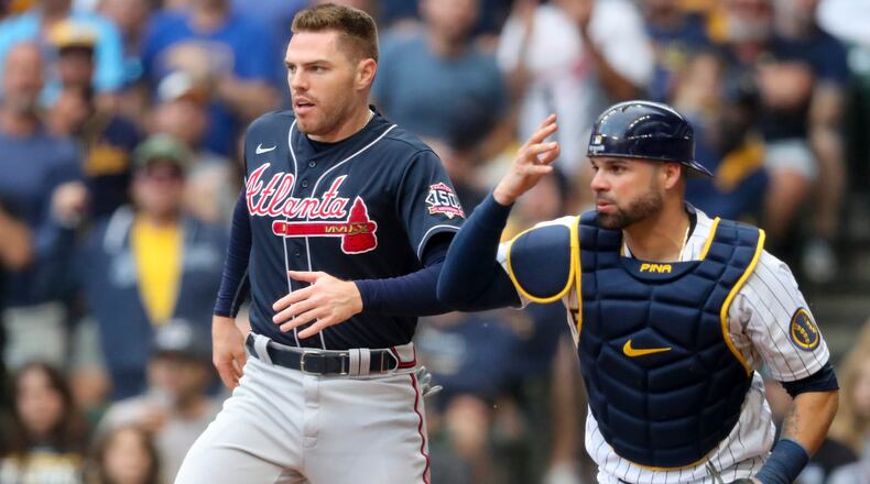 Former Brewers catcher Manny Pina, shown here with Braves star Freddie Freeman during the National League Division Series in October, has signed a two-year contract with the Braves. (Curtis Compton/ccompton@ajc.com)