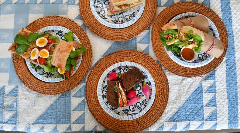 When you're headed to the beach or the mountains, great sandwiches to take along include Muffuletta (top), Vietnamese Beach Baguette (right), Swedish Picnic Loaf (bottom), and Pan Bagnat (left). (Styling by Lisa Hanson / Chris Hunt for the AJC)