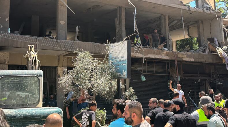 People gather at the site of an Israeli airstrike that struck an apartment in Dahiyeh, Beirut's southern suburbs, Lebanon, Sunday, June 14, 2026. (AP Photo/Bilal Hussein)
