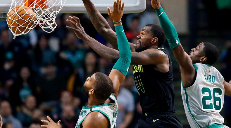 Atlanta Hawks' Dewayne Dedmon (14) dunks against Boston Celtics' Greg Monroe, left, and Jabari Bird (26) during the fourth quarter of an NBA basketball game in Boston, Sunday, April 8, 2018. The Hawks won 112-106. (AP Photo/Michael Dwyer)