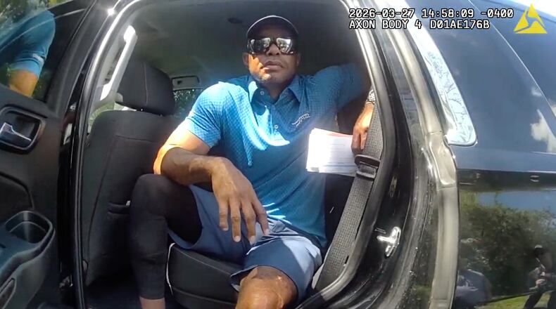 FILE - In this image from police body camera video released by the Martin County, Fla., Sheriff's Office, golfer Tiger Woods sits in an unmarked police vehicle as he speaks with law enforcement personnel following a car crash in Jupiter Island, Fla., March 27, 2026. (Martin County Sheriff's Office via AP, File)
