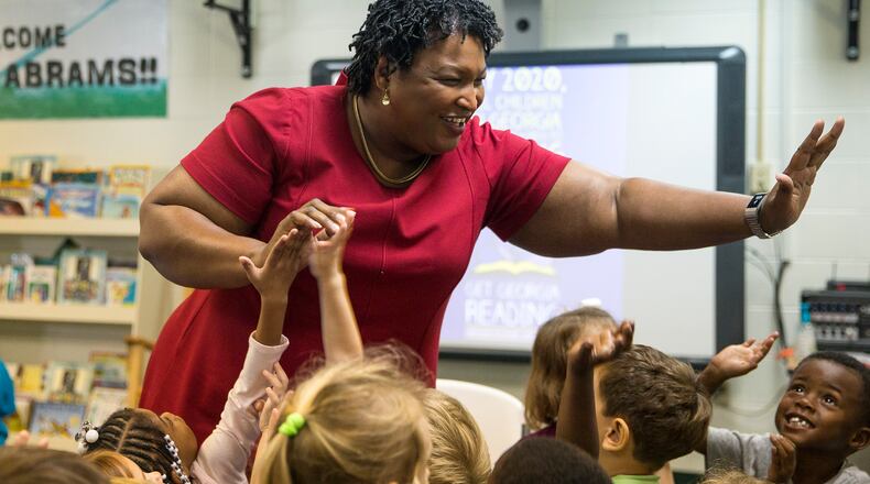 Stacey Abrams touches the hands of multiple preschool-aged children after reading them a children's book during a "Get Georgia Reading" literacy campaign stop at Seminole County Elementary School in Donalsonville, Ga. (File photo)